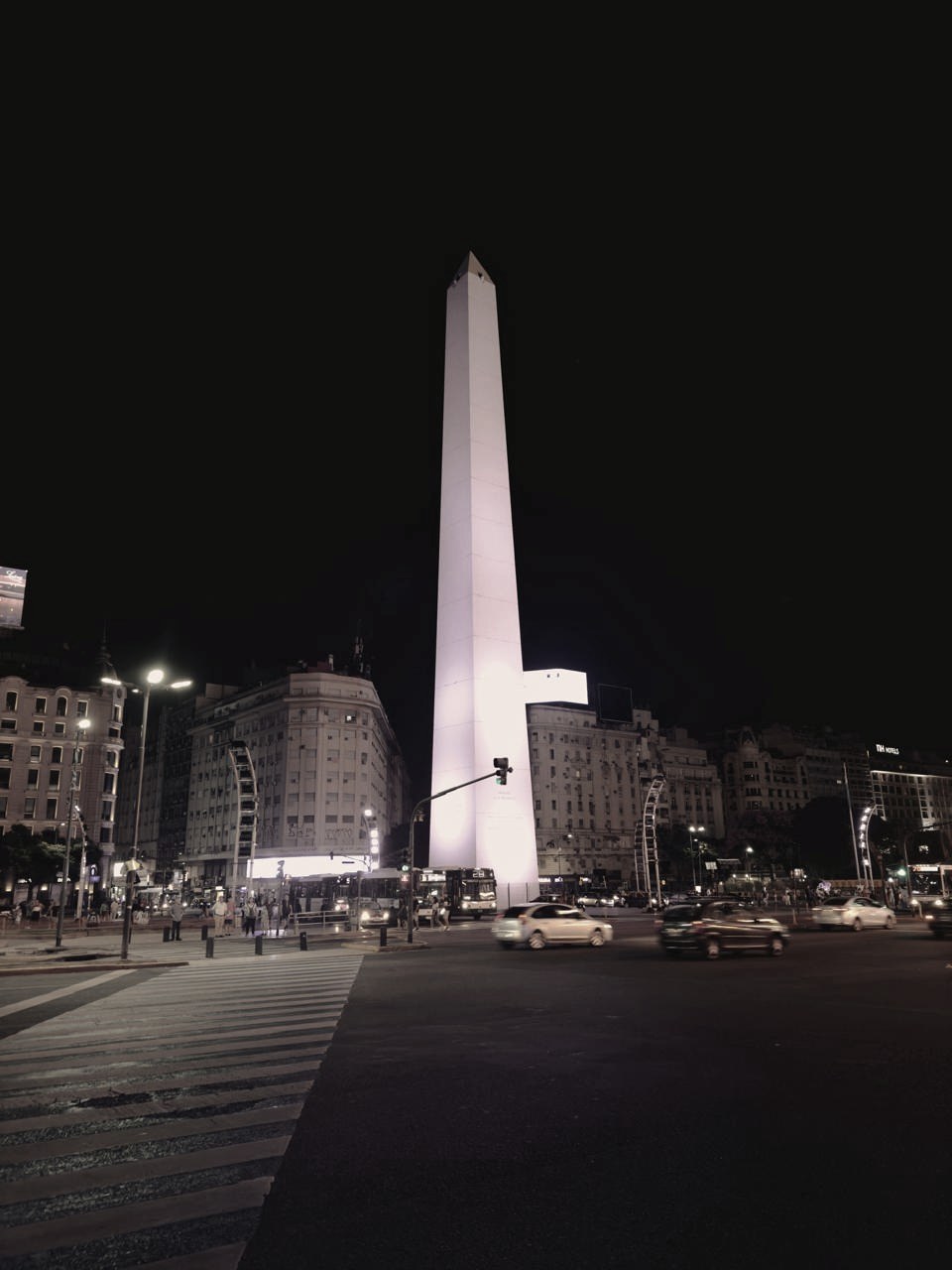 El Obelisco de Buenos Aires de noche, con tránsito y edificios iluminados